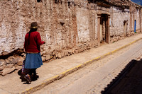 Quechuan woman walks down a street in Maras